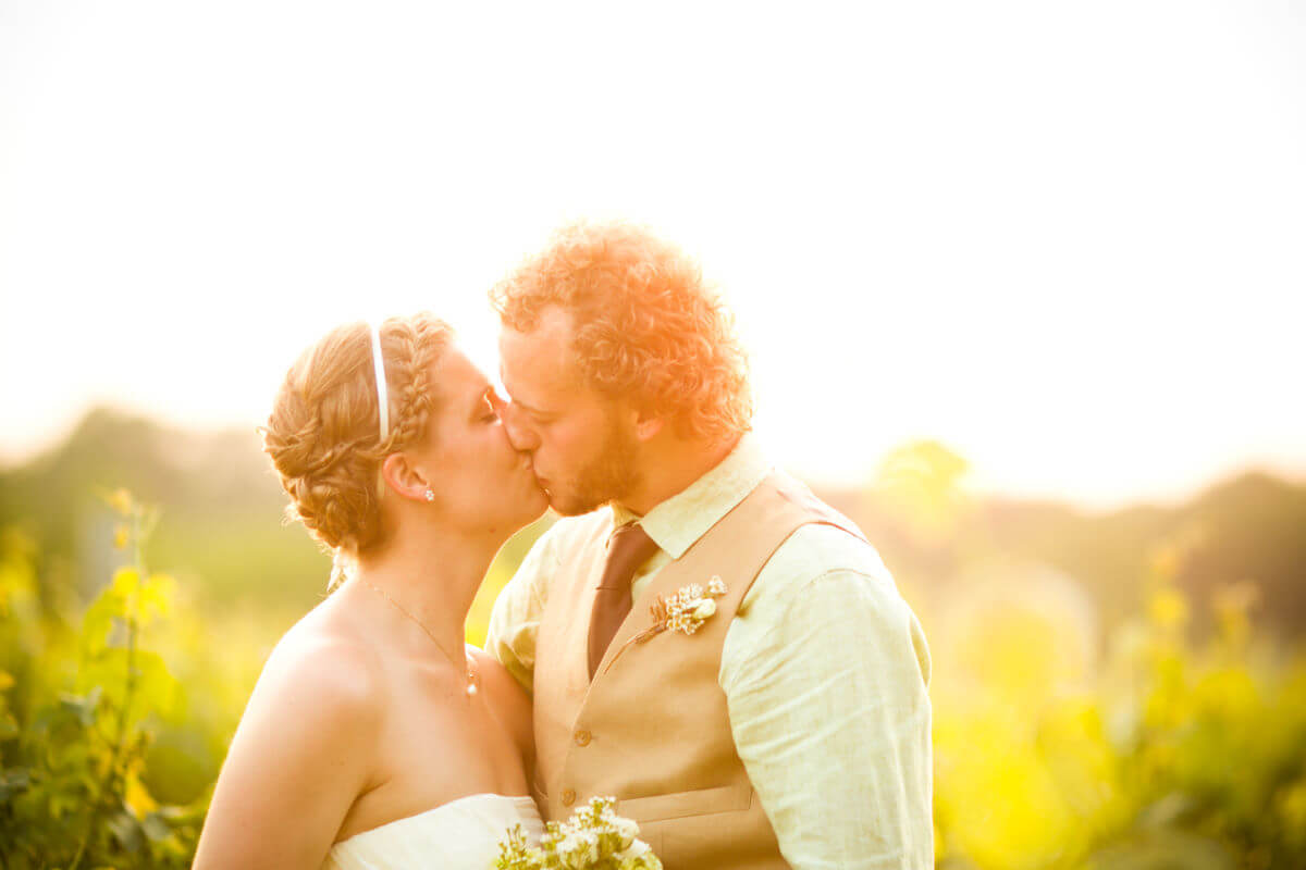 Beautiful Wedding Couple Share A Kiss During A Sunset