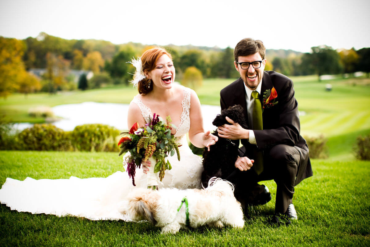 Joyful Bride And Groom Share A Moment With Dogs During Their Wedding