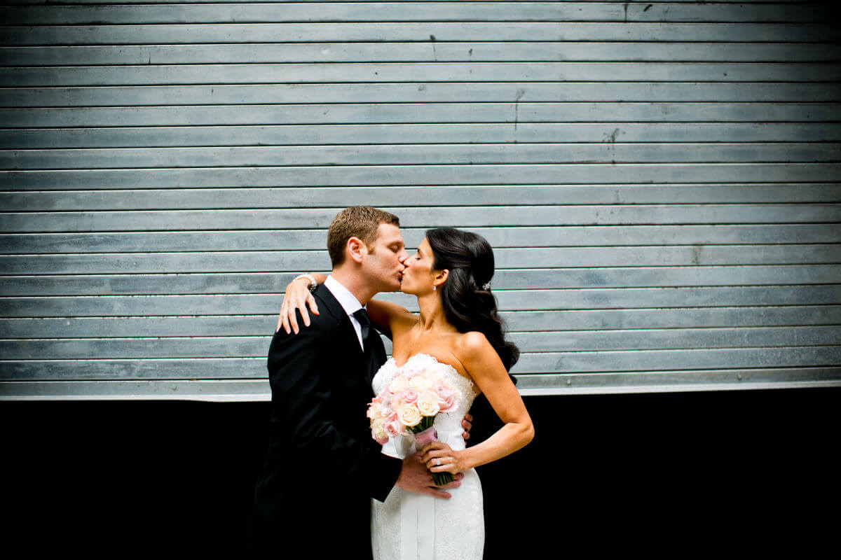 Wedding Couple Kissing In The Urban Environment