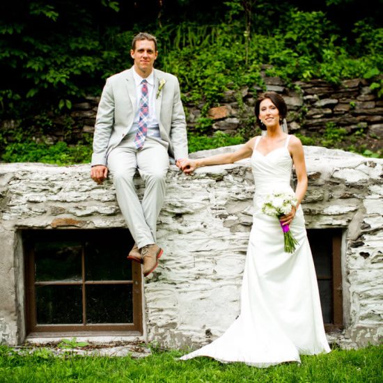 Wedding Couple Posing On The Wall Surrounded By Untouched Nature